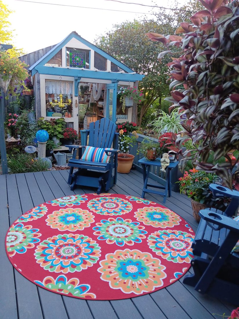 A cottage garden with pergola and Adirondack seating