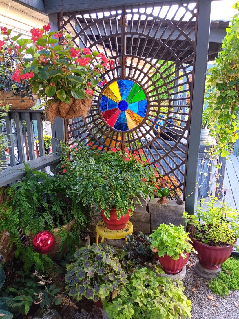 A pergola with pinwheels and potted plants